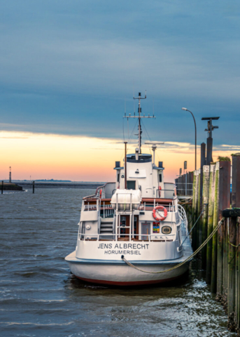 Foto eines angetauten Schiffes vor dem Abendhimmer